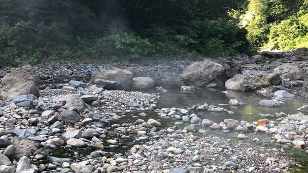 川からのぼる温泉の湯気
